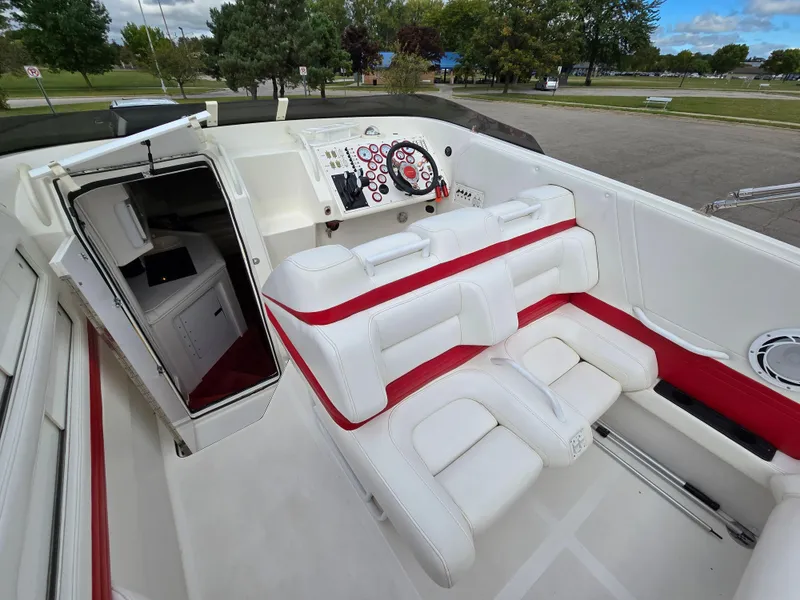 Slide: The Image of 1995 Fountain 38 Sport Cruiser interior with white and red seating, dashboard, and open cabin door. - 25