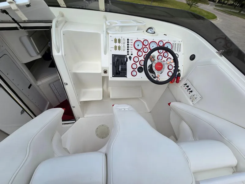 Slide: The Image of 1995 Fountain 38 Sport Cruiser helm with white seating and control panel. - 27