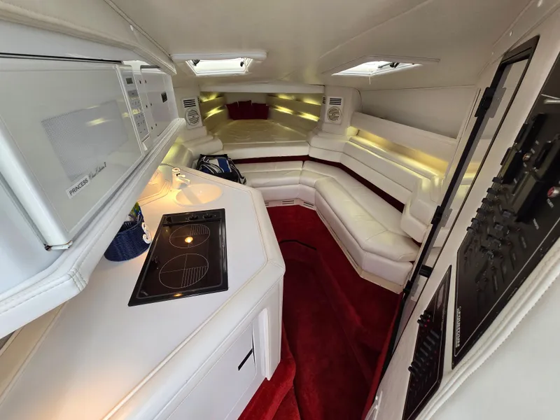 Slide: The Image of Luxurious interior of 1995 Fountain 38 Sport Cruiser with white seating and red carpet. - 35
