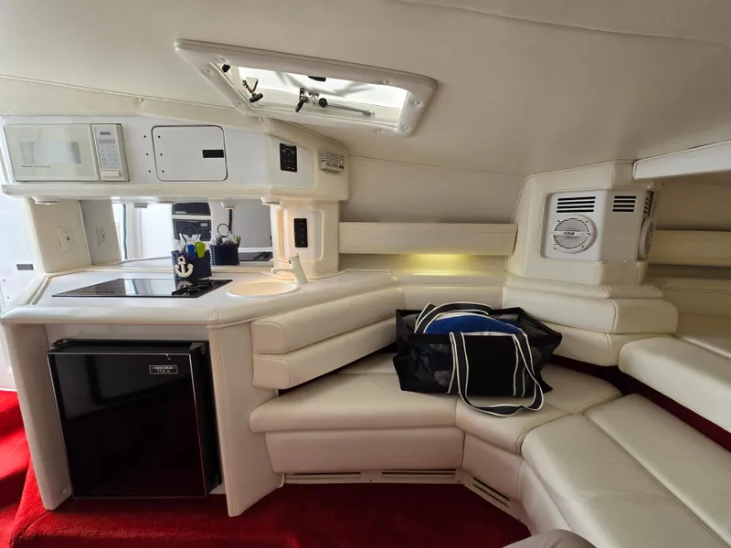 Slide: The Image of Interior of 1995 Fountain 38 Sport Cruiser with white seating and kitchenette. - 38