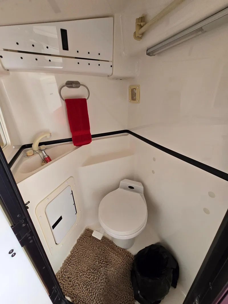 Slide: The Image of 1995 Fountain 38 Sport Cruiser bathroom with toilet, red towel, and beige rug. - 42
