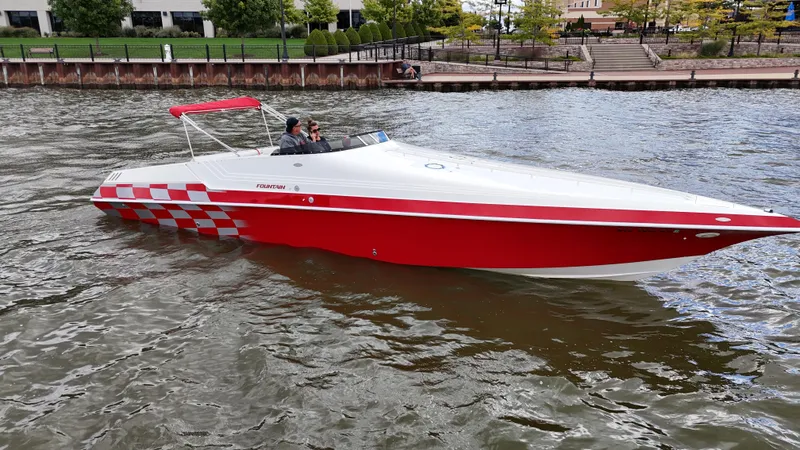 Slide: The Image of Red and white 1995 Fountain 38 Sport Cruiser boat on a river. - 44