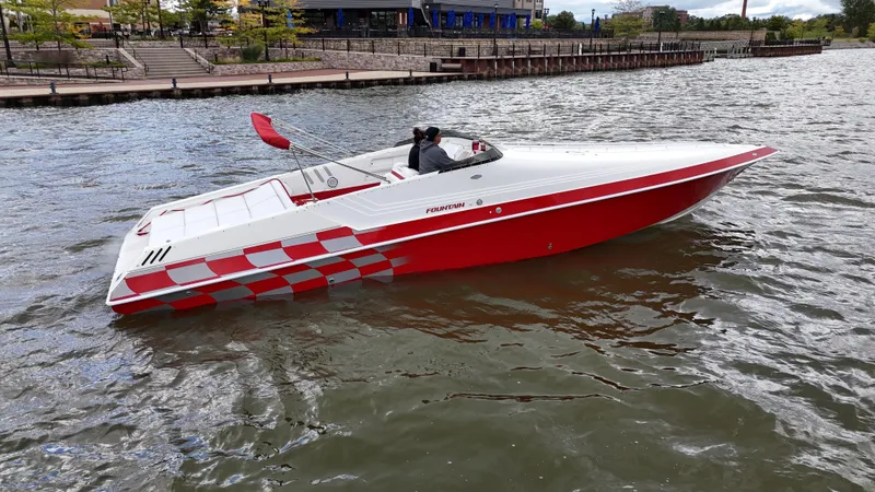 Slide: The Image of 1995 Fountain 38 Sport Cruiser boat on a river, featuring red and white design. - 45