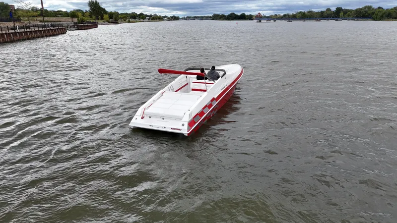 Slide: The Image of 1995 Fountain 38 Sport Cruiser on a calm river, featuring sleek red and white design. - 46