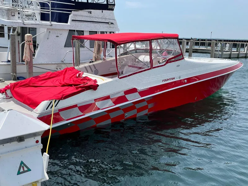 Slide: The Image of 1995 Fountain 38 Sport Cruiser boat with red and white design docked in marina. - 8