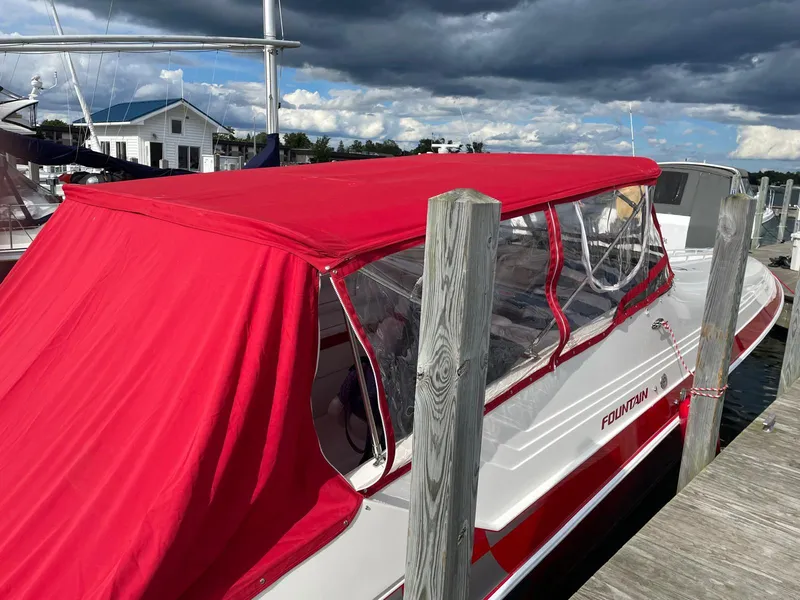 Slide: The Image of 1995 Fountain 38 Sport Cruiser with red canopy docked at marina. - 9