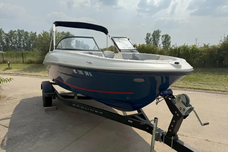 The Image of 2022 Bayliner VR4 Bowrider I/O on trailer, parked outdoors under cloudy sky. - 0