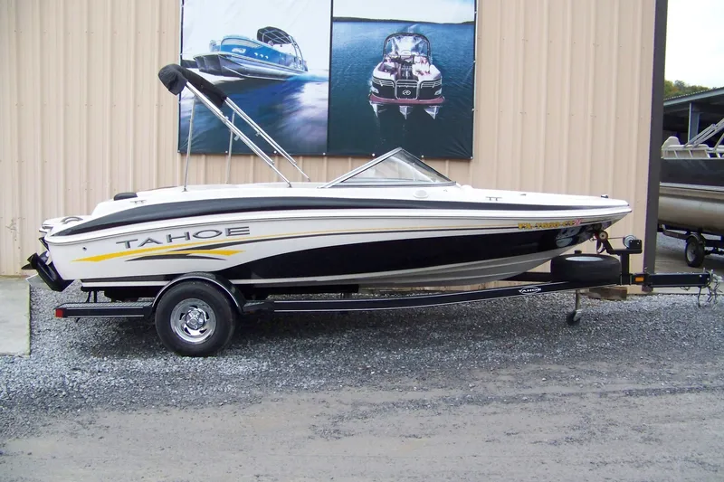 The Image of 2005 Tahoe Q4 I/O boat on trailer, parked outside a building. - 0
