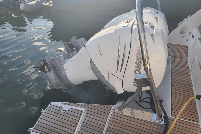 Slide: The Image of 2021 Beneteau Flyer 10 with twin Mercury outboard engines, docked on wooden deck. - 21