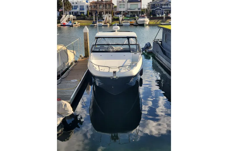 Slide: The Image of 2021 Beneteau Flyer 10 docked in a marina, reflecting on calm water. - 3
