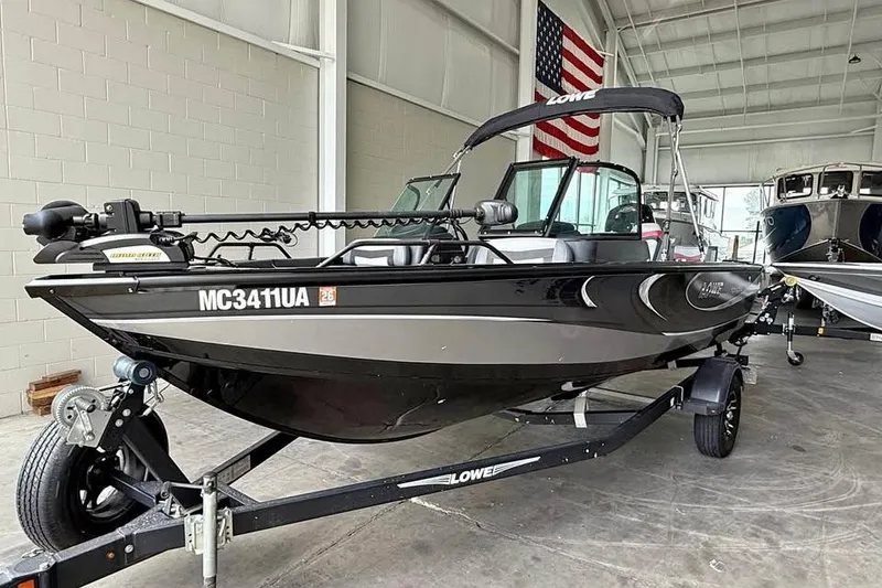 Slide: The Image of 2017 Lowe Fish & Ski 1710 boat in showroom with American flag backdrop. - 0