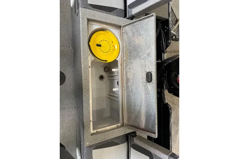 Slide: The Image of 2017 Lowe Fish & Ski 1710 boat storage compartment with open lid and yellow container. - 16