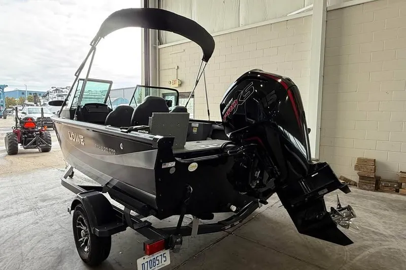 Slide: The Image of 2017 Lowe Fish & Ski 1710 boat with outboard motor in a garage setting. - 4