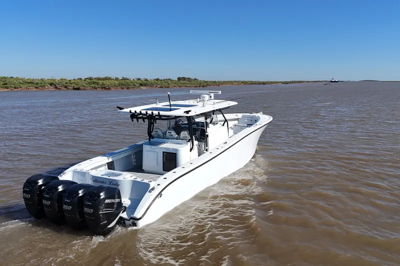 Slide: The Image of 2016 Yellowfin 42 Offshore boat cruising on a river with triple Mercury engines. - 10