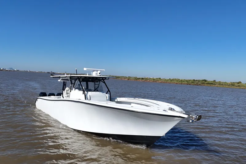 Slide: The Image of 2016 Yellowfin 42 Offshore boat cruising on a calm river under clear blue skies. - 11