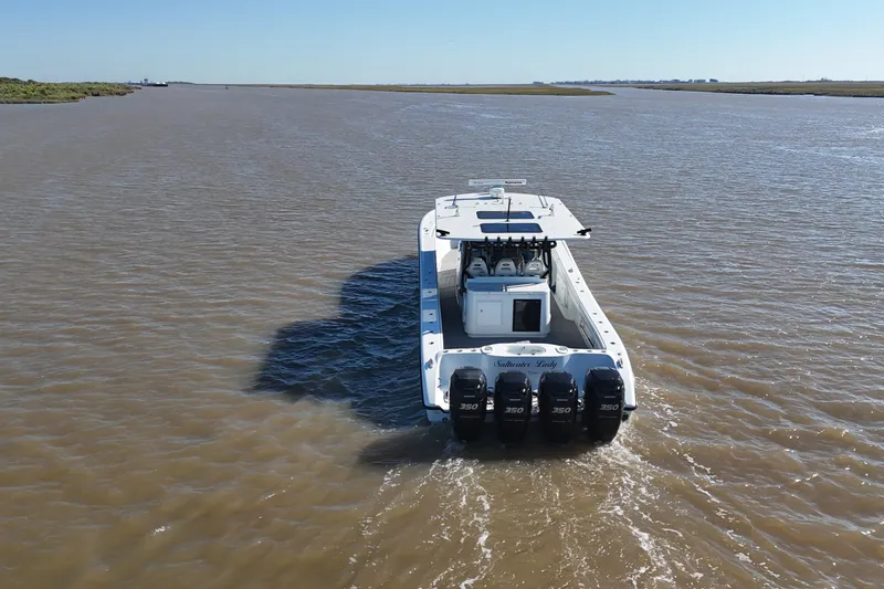 Slide: The Image of 2016 Yellowfin 42 Offshore boat cruising on a wide river with four powerful engines. - 13