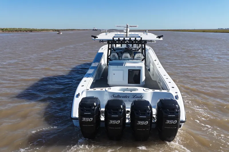 Slide: The Image of 2016 Yellowfin 42 Offshore boat with four powerful outboard engines on a calm waterway. - 14