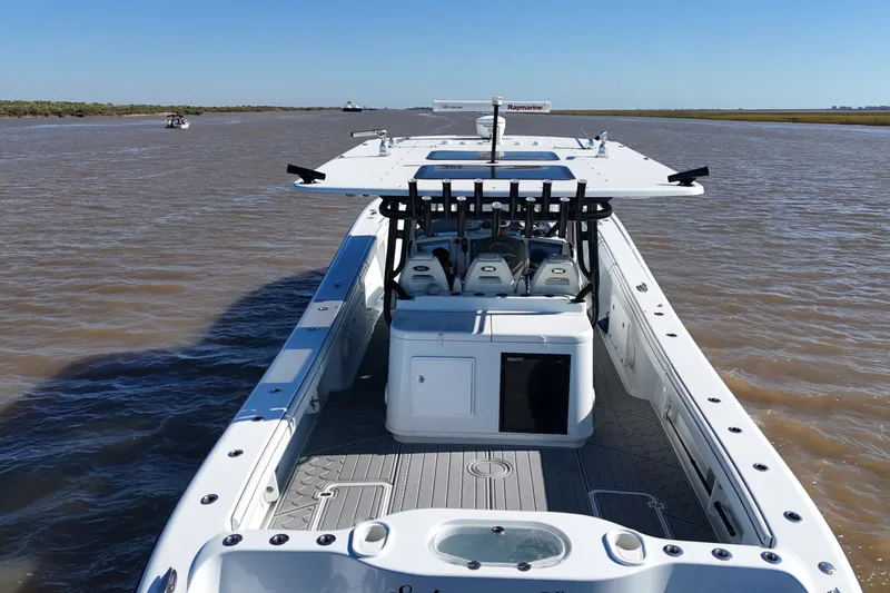 Slide: The Image of 2016 Yellowfin 42 Offshore boat cruising on a calm river under clear blue skies. - 18
