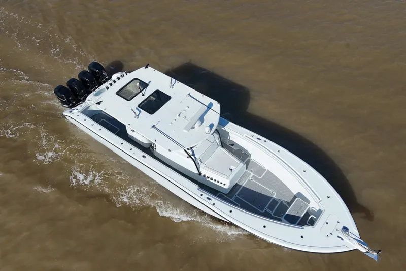Slide: The Image of 2016 Yellowfin 42 Offshore boat cruising on brown water, aerial view. - 2