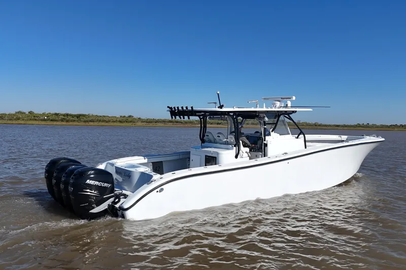 Slide: The Image of 2016 Yellowfin 42 Offshore boat cruising on a calm river under clear blue skies. - 21