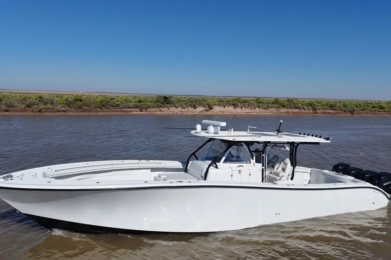 Slide: The Image of 2016 Yellowfin 42 Offshore boat cruising on a calm river under clear blue skies. - 24