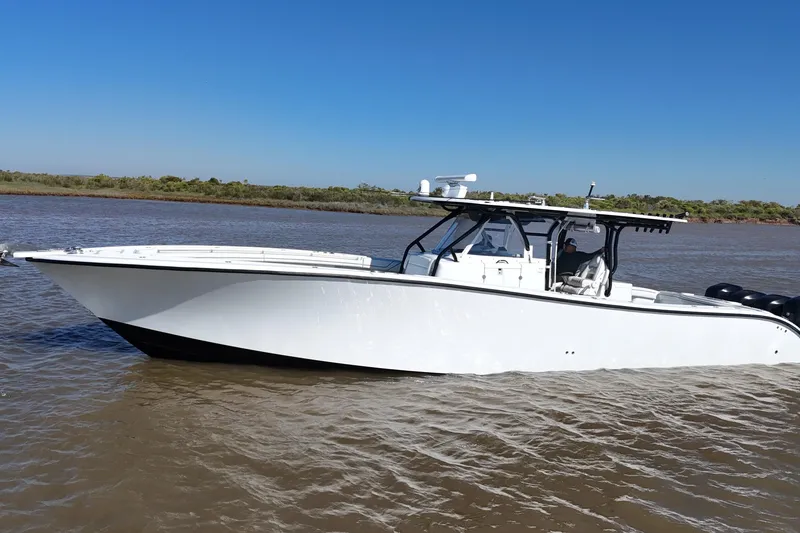 Slide: The Image of 2016 Yellowfin 42 Offshore boat cruising on a calm river under clear blue skies. - 28