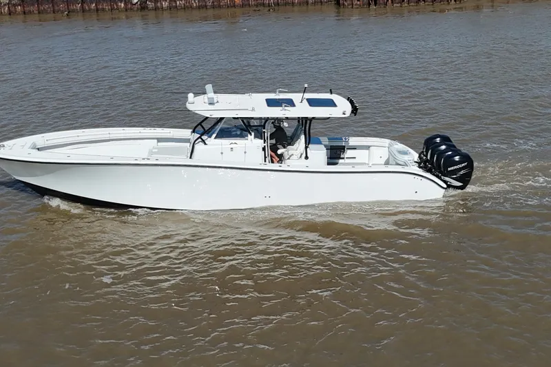 Slide: The Image of 2016 Yellowfin 42 Offshore boat cruising on a river with triple Mercury engines. - 32