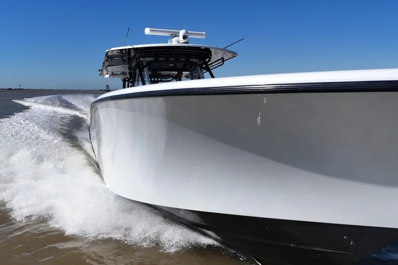 Slide: The Image of 2016 Yellowfin 42 Offshore boat cruising on open water, creating a dynamic wake. - 34
