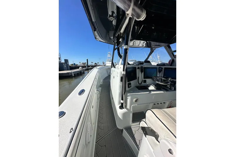 Slide: The Image of 2016 Yellowfin 42 Offshore boat interior with helm, docked under clear blue sky. - 37
