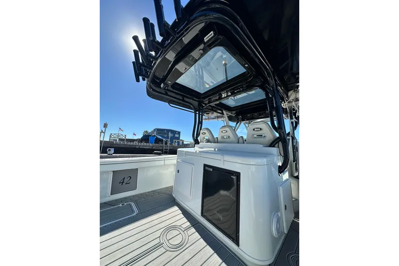 Slide: The Image of 2016 Yellowfin 42 Offshore boat interior with seating and rod holders under clear sky. - 51