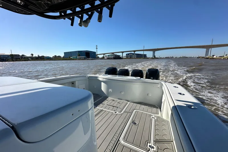 Slide: The Image of 2016 Yellowfin 42 Offshore boat cruising on a sunny day, with bridge and buildings in view. - 57