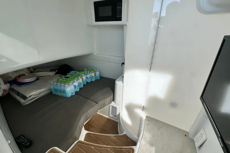 Slide: The Image of Interior cabin of 2016 Yellowfin 42 Offshore boat with bed, microwave, and water bottles. - 68