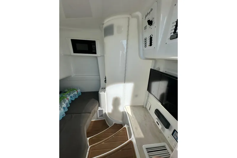 Slide: The Image of 2016 Yellowfin 42 Offshore cabin interior with microwave, seating, and control panels. - 70