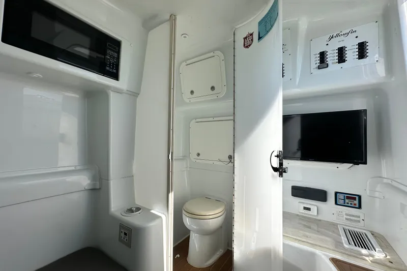 Slide: The Image of 2016 Yellowfin 42 Offshore boat interior with toilet, microwave, and control panel. - 72