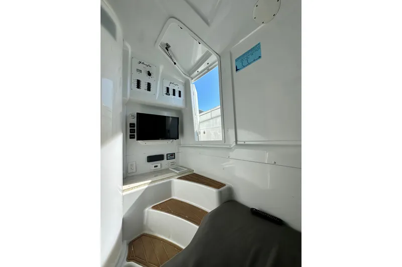 Slide: The Image of 2016 Yellowfin 42 Offshore cabin interior with TV and control panels. - 73
