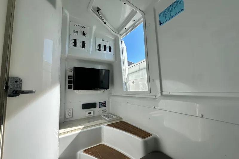 Slide: The Image of Interior of 2016 Yellowfin 42 Offshore boat with control panels and a small TV. - 74