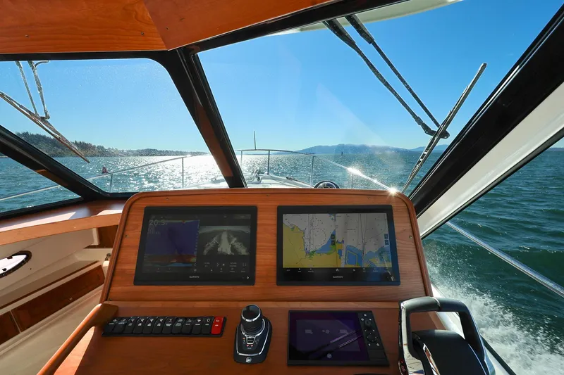 Slide: The Image of 2024 Back Cove 39O helm with navigation screens, cruising on open water. - 19