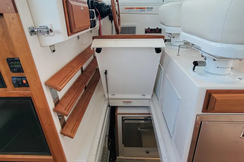 Slide: The Image of 2024 Back Cove 39O interior with wooden accents and white seating. - 22