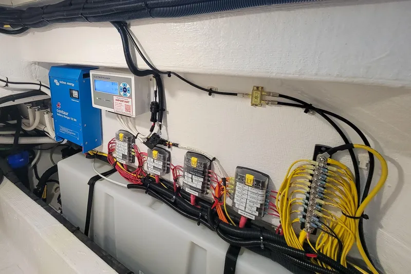 Slide: The Image of 2024 Back Cove 39O under helm storage area with Hybrid stainless drawer Refrigerator/Freezer , water heater, Battery charger and wiring access. - 24