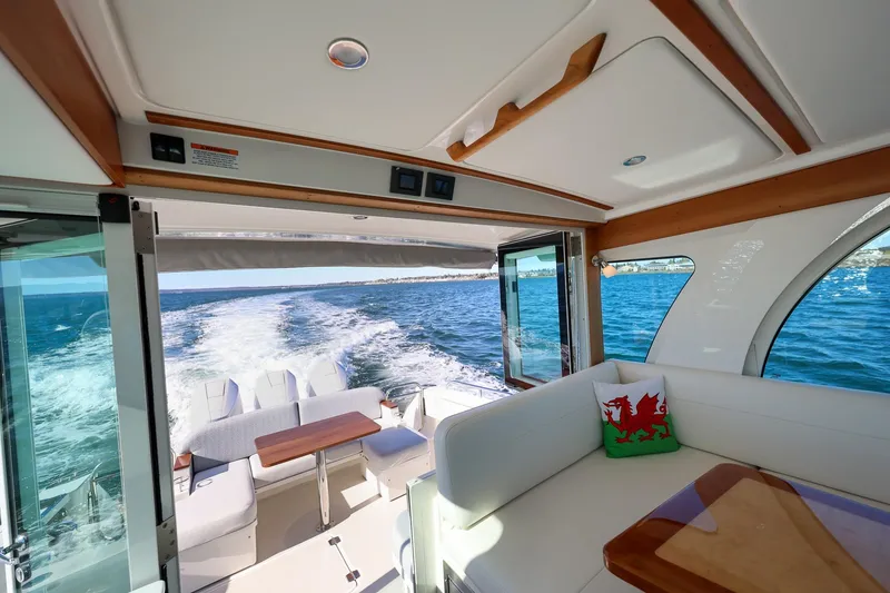 Slide: The Image of 2024 Back Cove 39O yacht interior with ocean view, featuring elegant seating and wooden accents. - 29