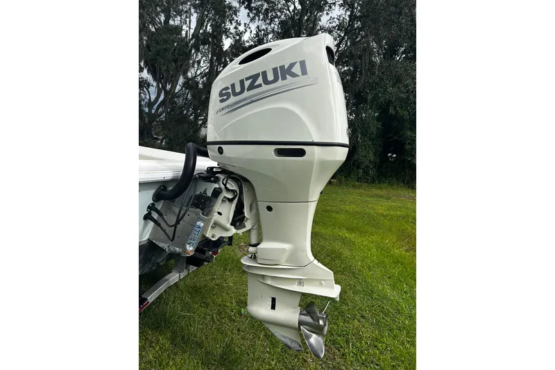 Slide: The Image of Outboard motor on a Hanson 23 boat, 2024 model, in a grassy area. - 2