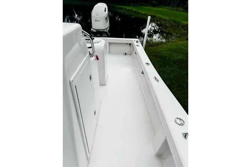Slide: The Image of 2024 Hanson 23 boat interior with Suzuki outboard motor near water. - 7