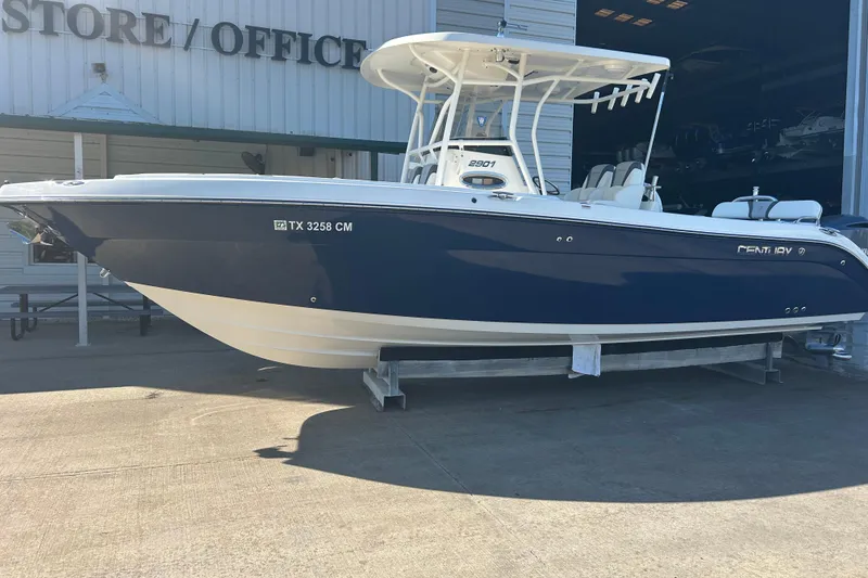 Slide: The Image of 2015 Century 2901 Center Console boat in blue, displayed outside a store. - 1