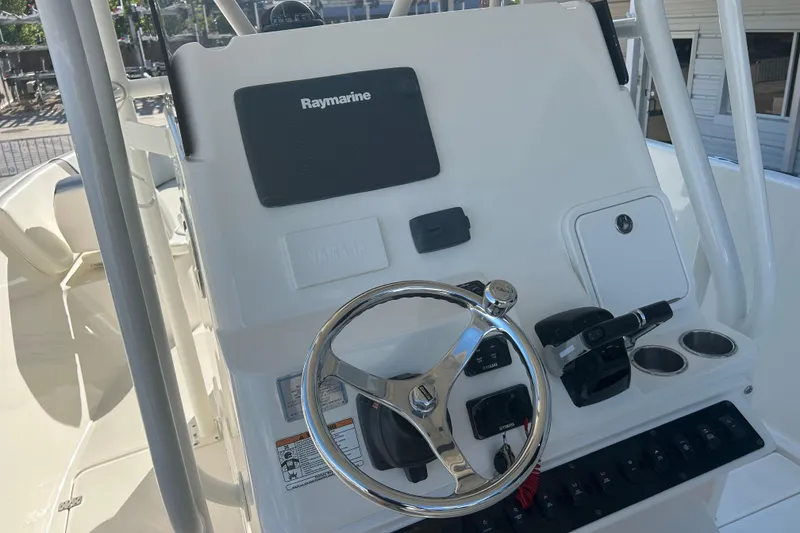 Slide: The Image of 2015 Century 2901 Center Console boat dashboard with Raymarine electronics and steering wheel. - 22