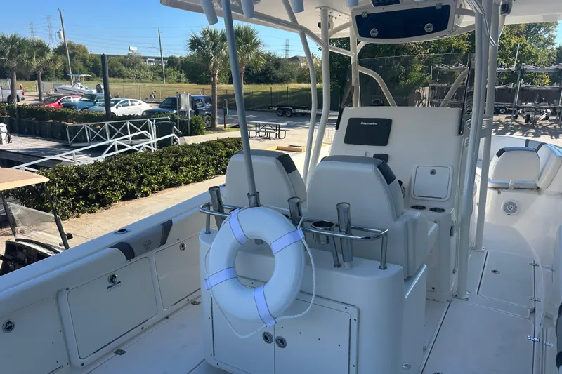 Slide: The Image of 2015 Century 2901 Center Console boat with seating and life preserver, docked outdoors. - 36