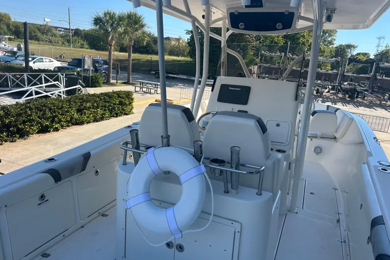 Slide: The Image of 2015 Century 2901 Center Console boat with seating and life preserver, docked outdoors. - 9