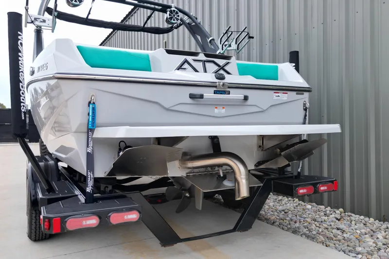 Slide: The Image of 2021 ATX Surf Boats 20 Type-S on trailer, rear view, near metal building. - 16