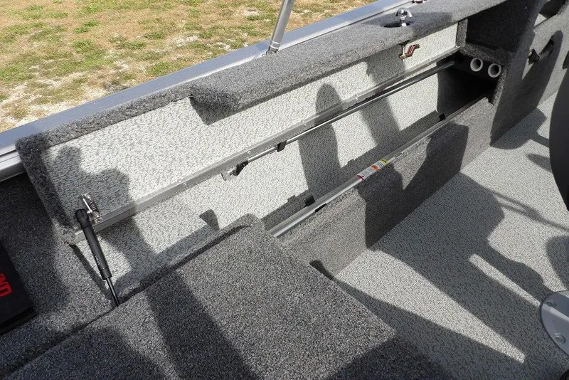 Slide: The Image of 2026 Lund 1875 Impact XS Sport boat interior with gray carpet and metal railing. - 17