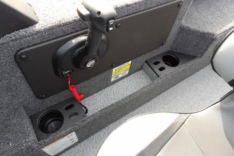 Slide: The Image of Storage compartment in 2026 Lund 1875 Impact XS Sport boat, featuring carpeted interior and speaker. - 28