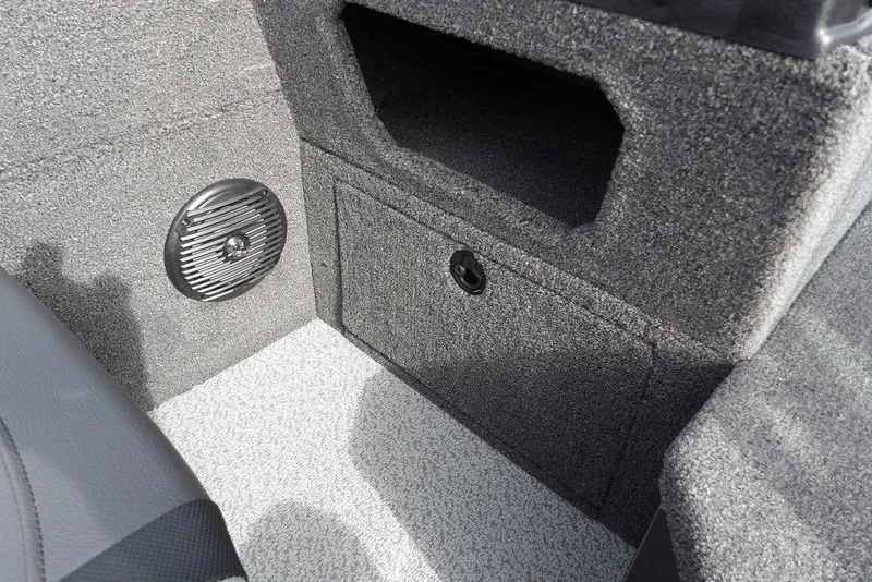 Slide: The Image of Interior view of 2026 Lund 1875 Impact XS Sport boat, featuring carpeted flooring and storage compartment. - 37